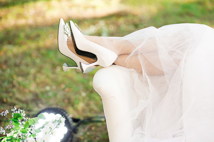 Legs of the bride in white shoes