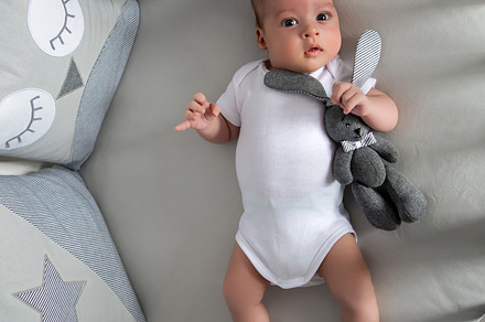 Newborn boy lies in a round bed containing background, family, and baby, a Person Photo by SaulichPhoto