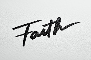 Handwritten word “Faith” in black, a Background Photo by MistyDay