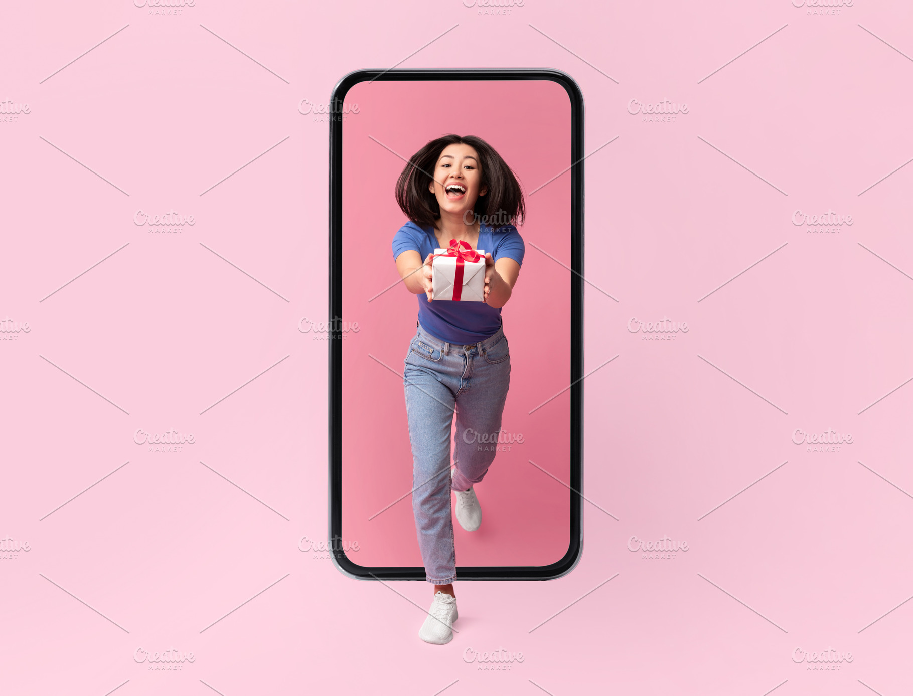 Joyful Korean Woman Giving Present From Big Smartphone, Pink Background, a Photo by Prostock-Studio