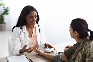 Black Doctor Woman Consulting Female Soldier And Checking Her Blood Pressure, a Photo by Prostock-Studio