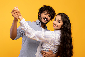 Romantic happy indian husband and wife hugging, holding hands and dancing, havi, a Photo by Prostock-Studio