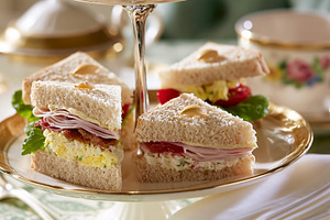 Assorted finger sandwiches with various fillings on a tiered stand, ready for a, a Photo by Studio ANNA