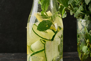 Glass bottle filled with detox water containing cucumber and lem, a Food & Drink Photo by ndanko