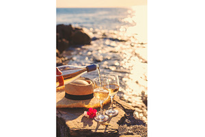 Wine in hands of woman against sea, a Food & Drink Photo by yanadjana