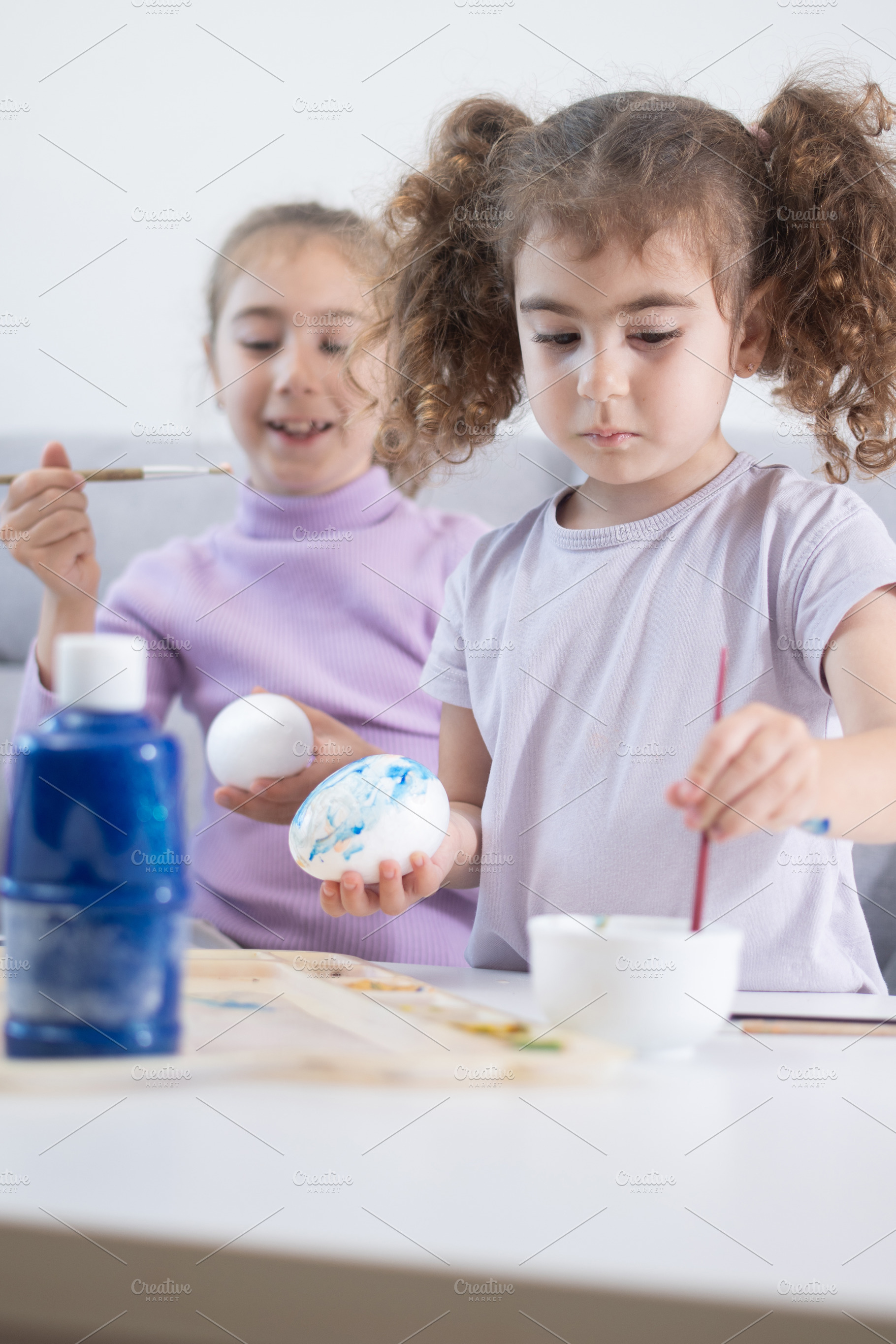 Two sisters decorating Easter eggs., a Person Photo by etorres69