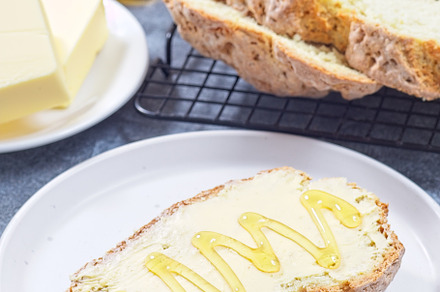 Freshly baked white Irish soda bread with butter and honey served on a plate, v