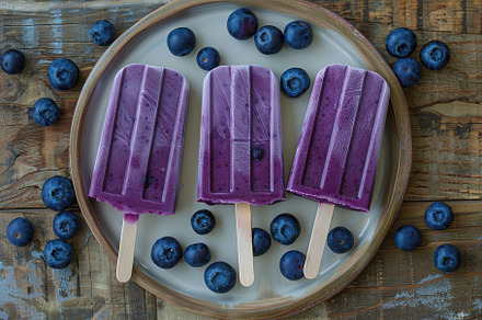 Ice cream popsicles with organic blueberries on wooden background, a Food & Drink Photo by AlyaAnd