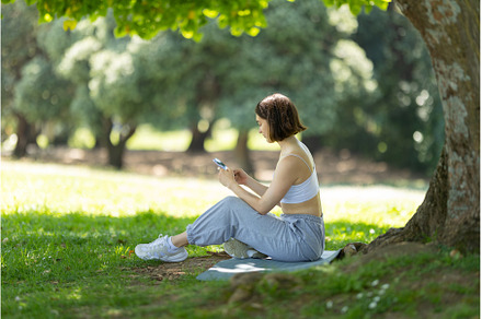 A woman is sitting under a tree and