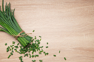 Freshly cut chives tied with twine on wooden table, a Food & Drink Photo by Olena Rudo