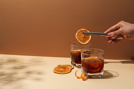 Concept of delicious alcohol drink, Whiskey with orange, a Food & Drink Photo by AtlasStudio