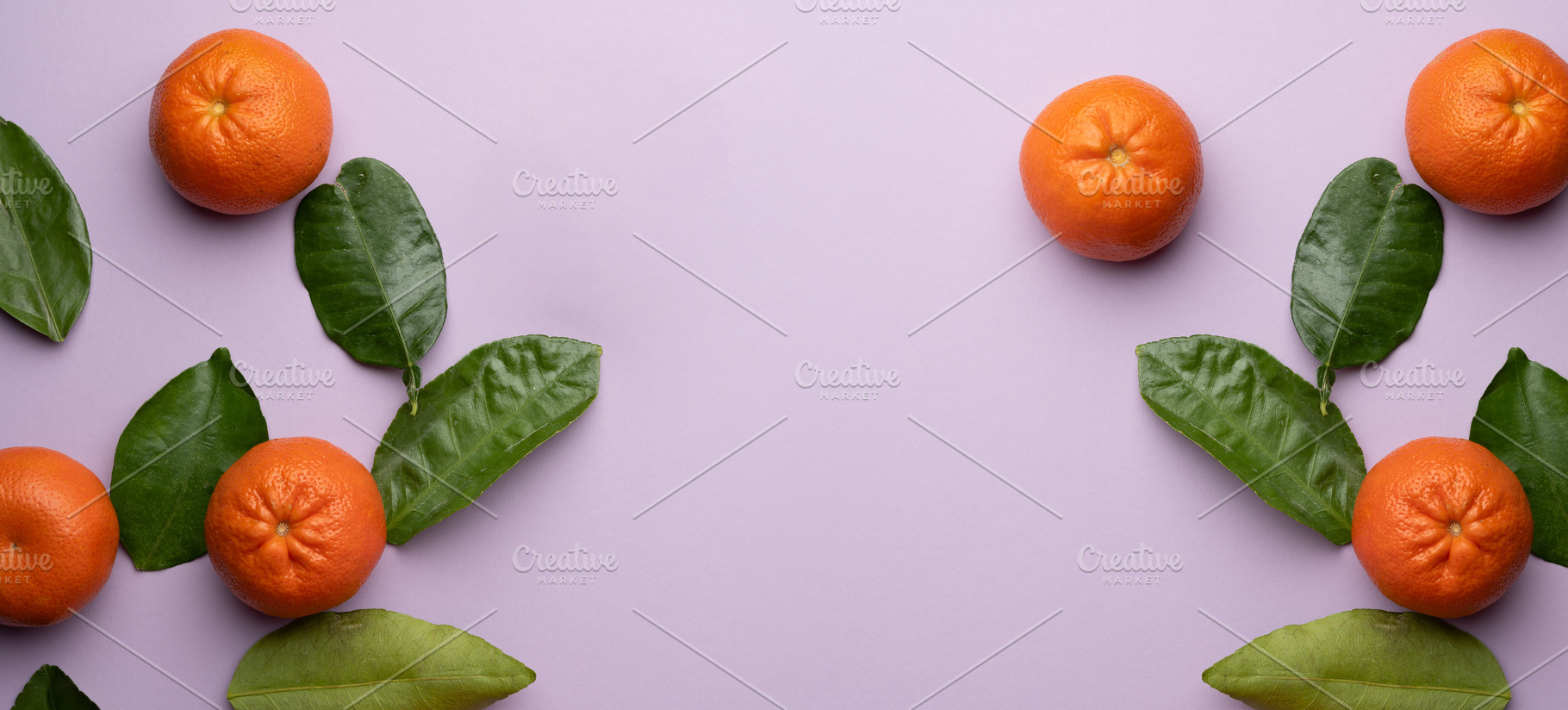 Ripe tangerines and green leaves on a purple background,, a Food & Drink Photo by ndanko