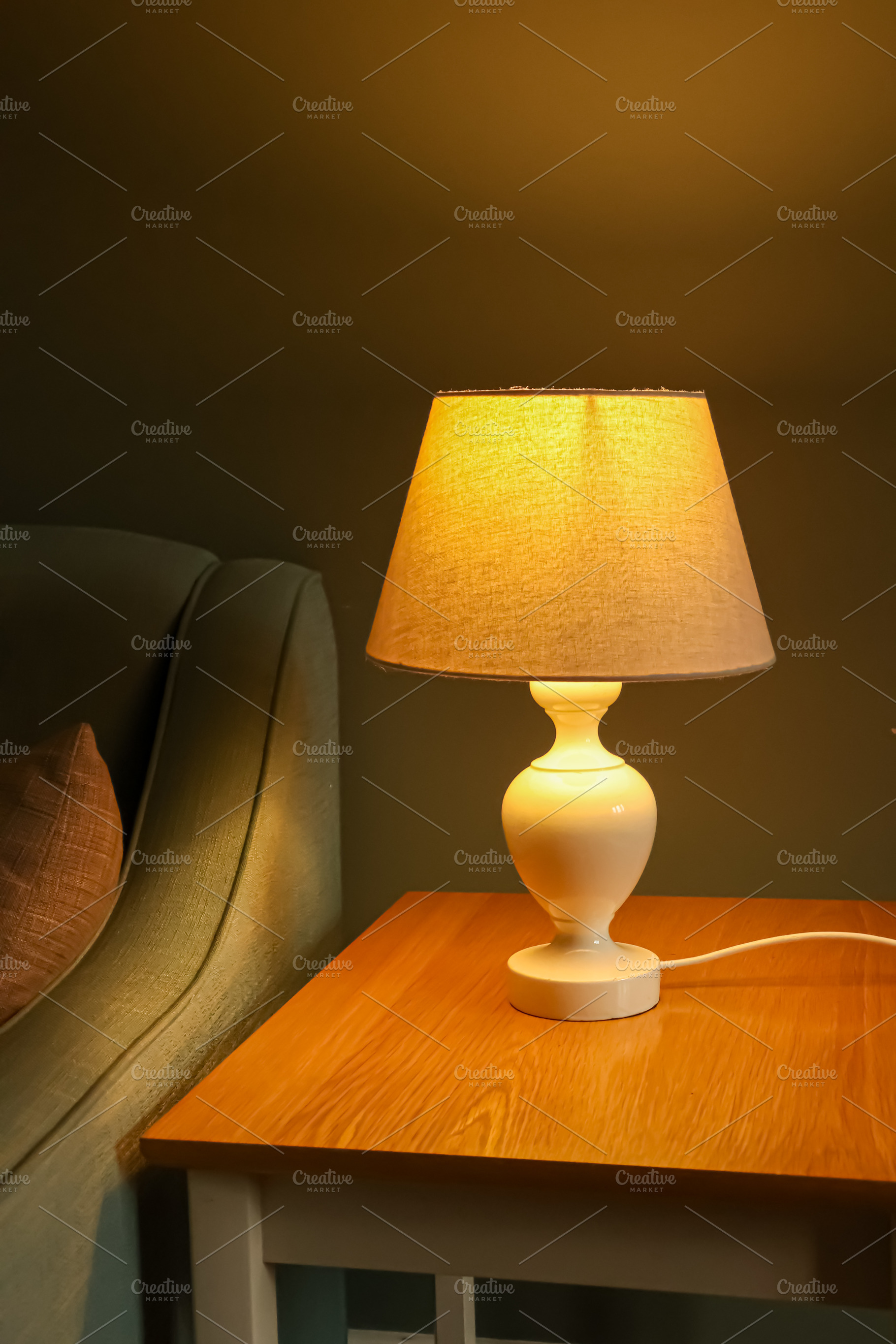 Cozy table lamp illuminating bedroom nightstand, creating warm ambiance for rel, a Photo by Studio ANNA