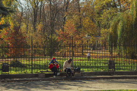 Photo of Lviv city in autumn season with people sitting on bench, an Architecture Photo by AtlasStudio PRO