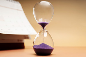 Hourglass beside calendar, time management, aging society and aw, a Photo by salmon.black