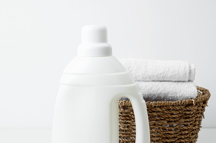 Laundry detergent branding mock up and basket filled with clean white towels. H