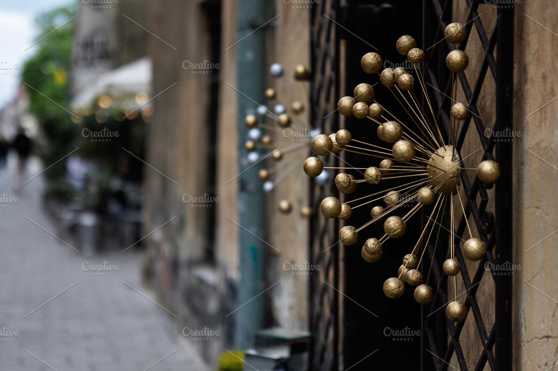Golden decorative design element on outdoor railing in urban street setting, a Photo by AS photostudio