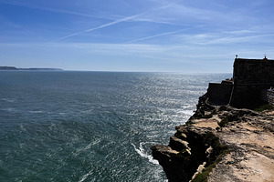 Dramatic coastal view of cliffs and ocean under a clear sky in Nazare, a Photo by AS photostudio