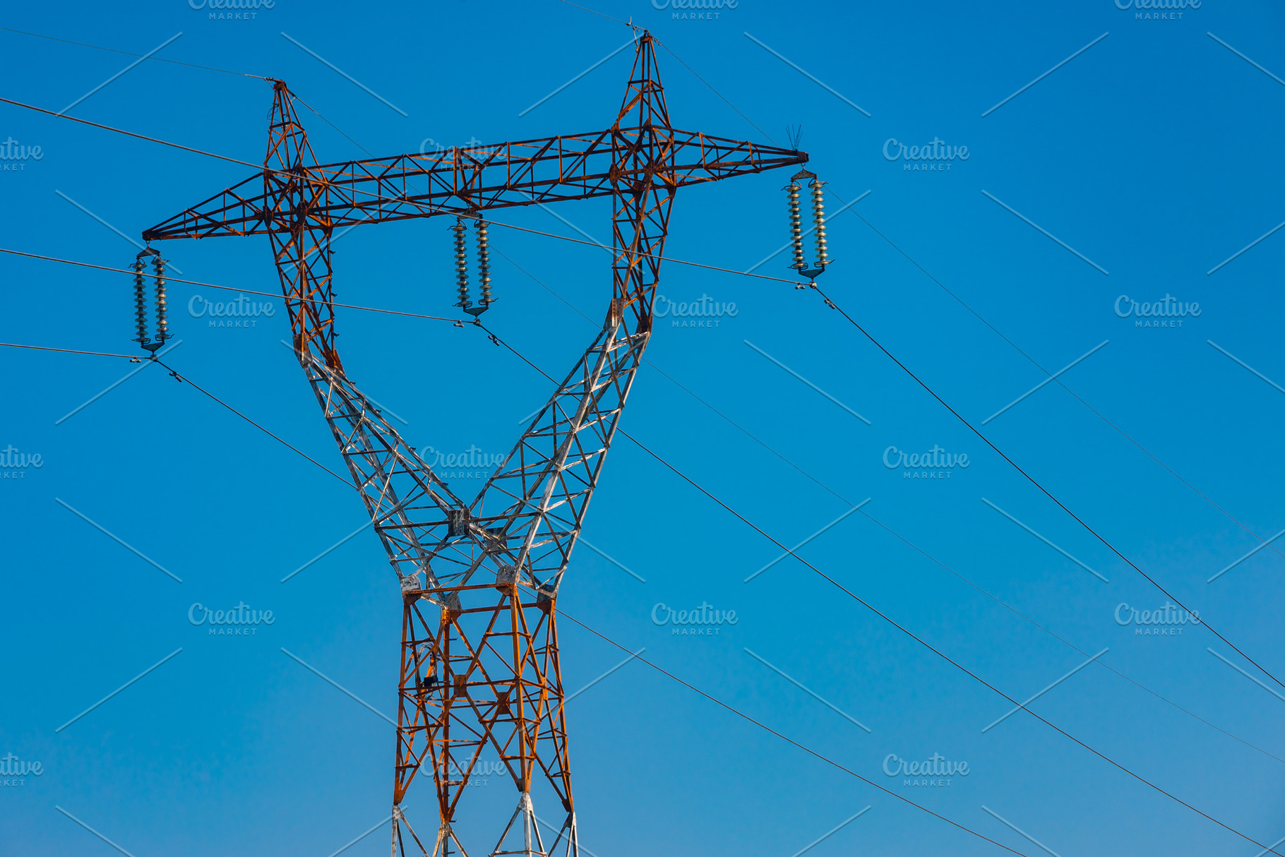 Tall metal electricity transmission tower with multiple power lines set against, a Technology Photo by Ales Munt