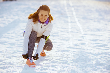 smiling young woman in white jacket tying your shoelaces, a Person Photo by Alliance Images