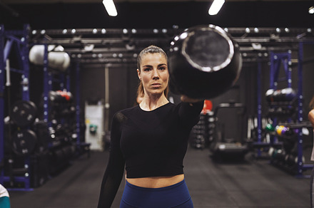 Young woman exercising with a dumbbell at the gym