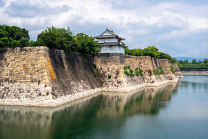 Stone walls and turret of Osaka Castle, Japan, with moat reflect, an Architecture Photo by GoodGoods