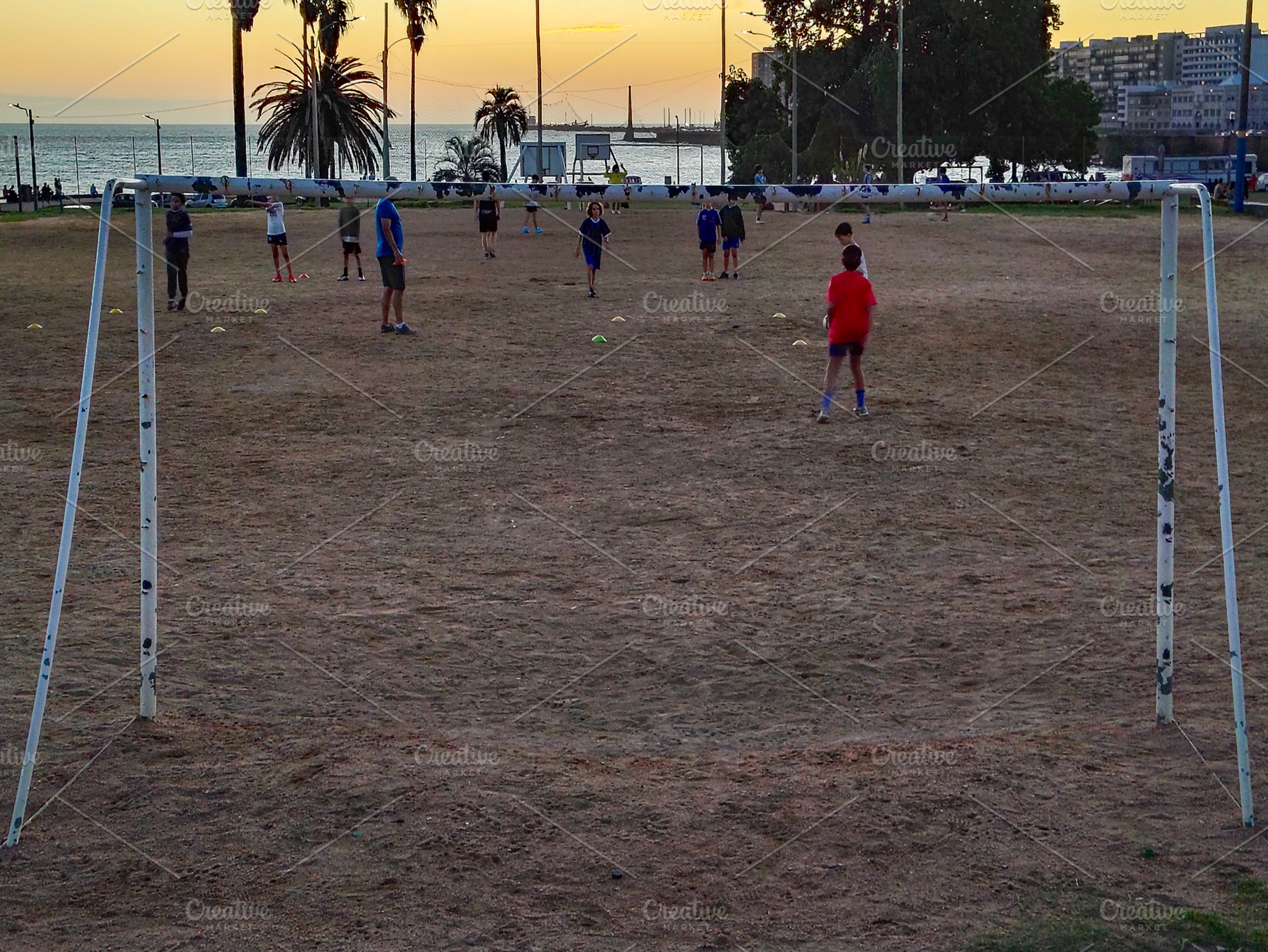 Kids playing soccer at sunset on dry field, a Sports & Recreation Photo by DanFLCreativo