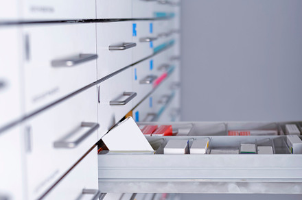 Pharmacy cabinet from side of drawer containing isolated, office, and people