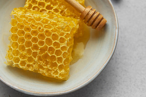 Honeycomb and honey dipper resting in bowl with fresh mint sprig, a Food & Drink Photo by Olena Rudo