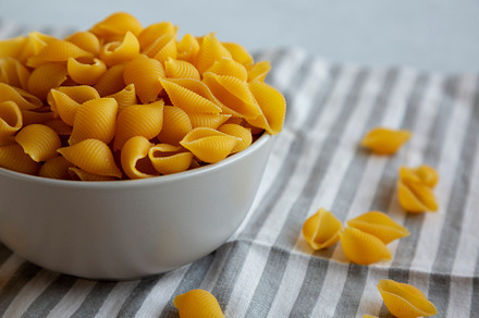 Dry Organic Medium Pasta Shells in a Bowl, side view., a Food & Drink Photo by LiudmylaChuhunova
