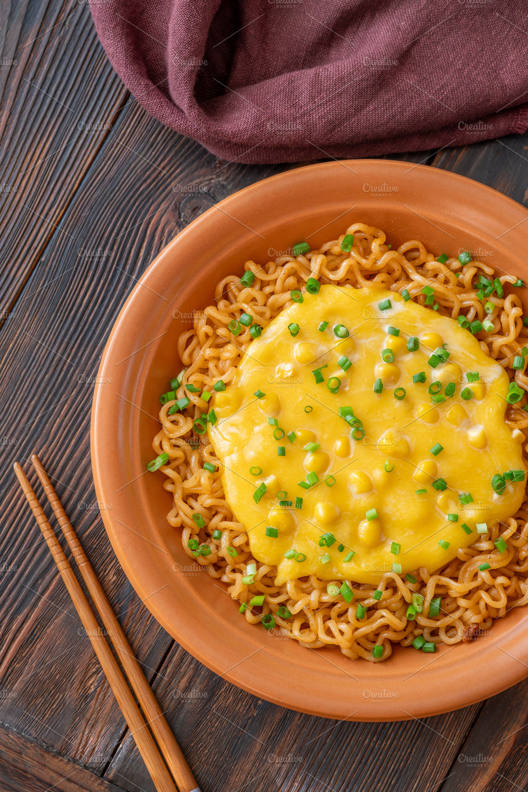 Cheesy corn ramen with scallions and wooden chopsticks on dark r, a Food & Drink Photo by Alexander Prokopenko