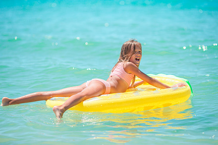 Little happy girl with inflatable air mattress in the sea having fun, a Person Photo by travnikovstudio