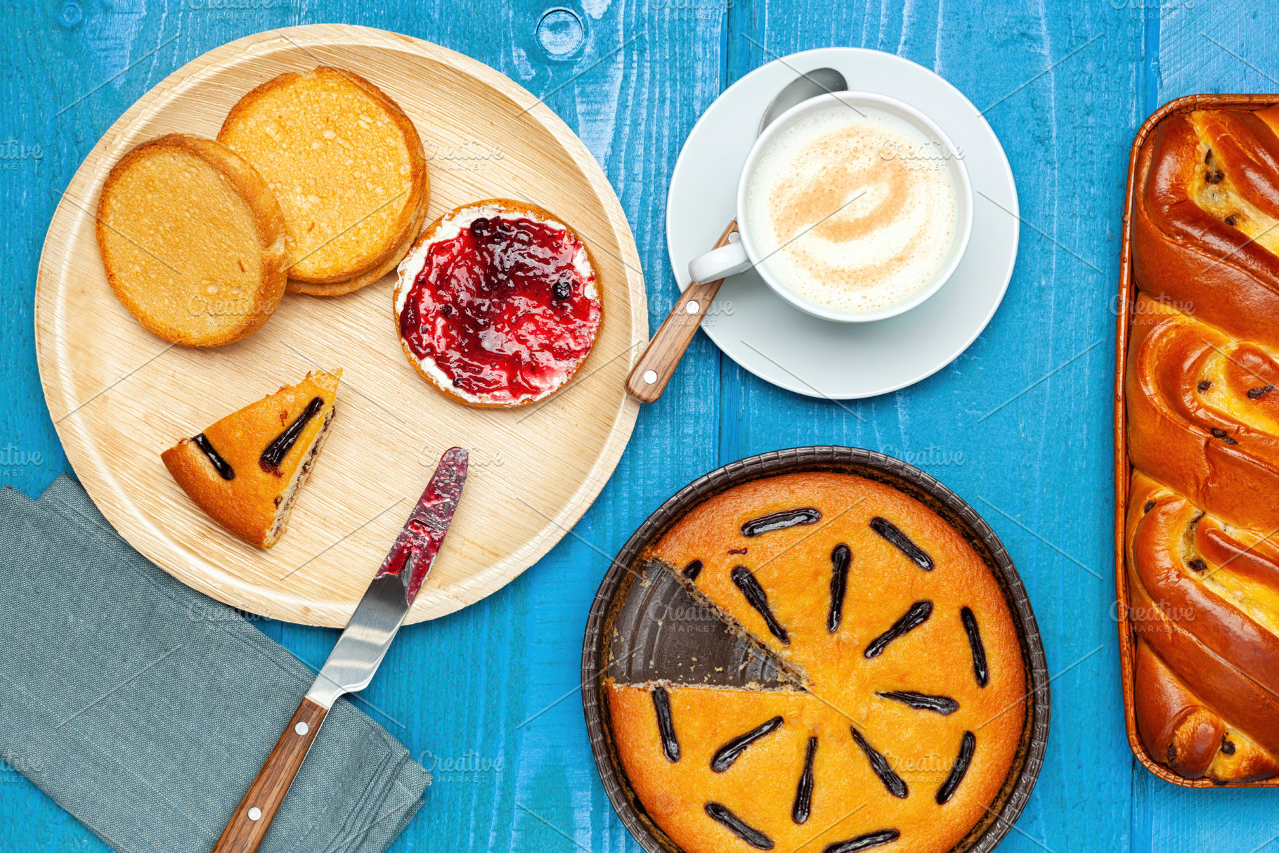 Delicious breakfast with cappuccino, cakes, rusks and jam on a blue wooden tabl, a Food & Drink Photo by Antonio Gravante Market