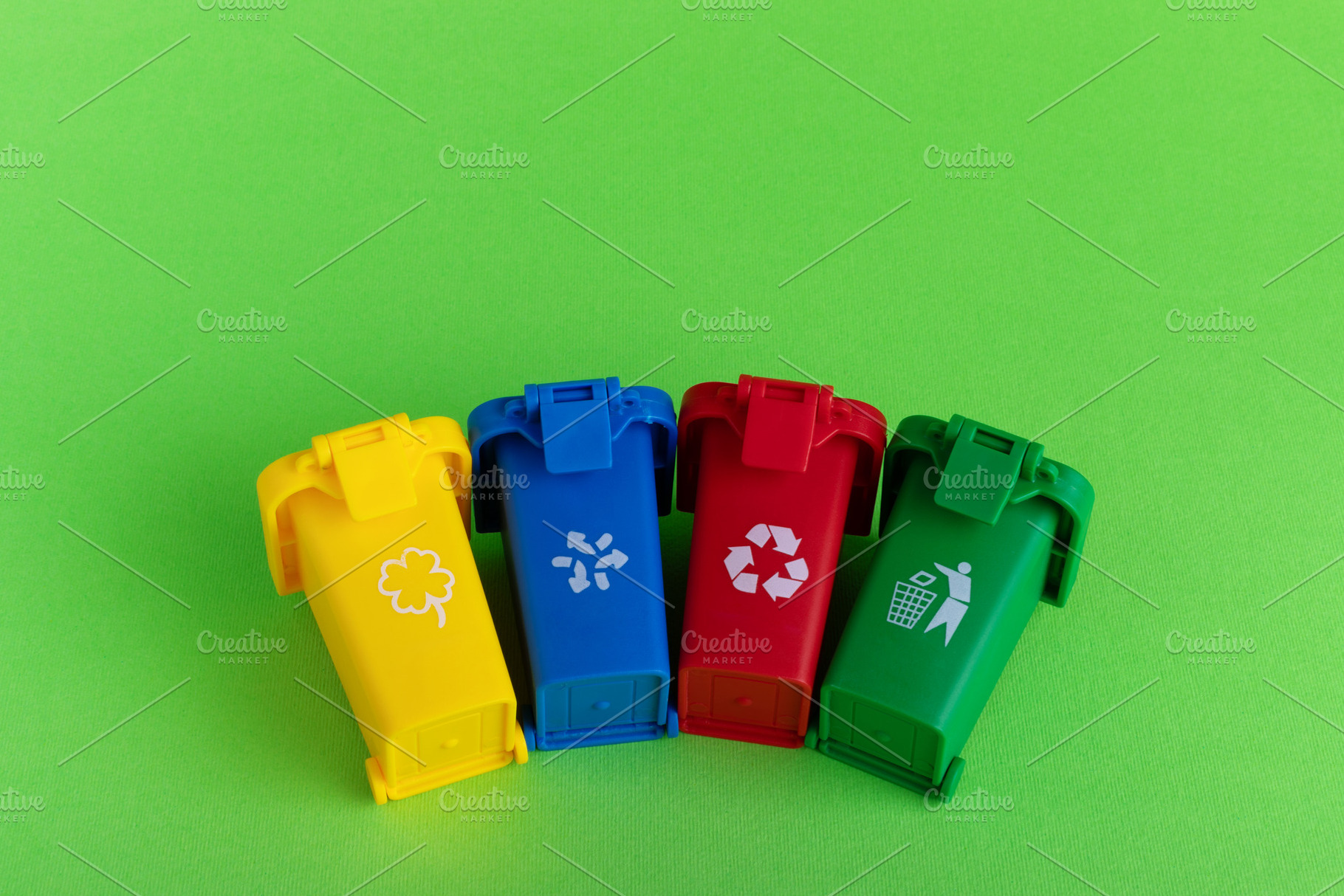 Four colorful recycling bins with waste icons on a green background, symbolizin, an Industrial Photo by Ales Munt