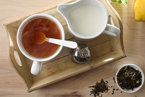 Cup of hot tea and milk on a wooden tray, a Food & Drink Photo by Davizro's Market