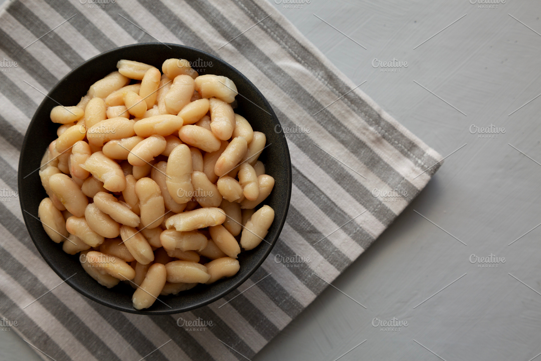 Organic Cannellini Beans in a Bowl, top view. Space for text., a Food & Drink Photo by LiudmylaChuhunova