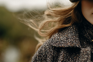 Woman's blonde hair blowing in the wind, wearing a tweed jacket, a Photo by Studio ANNA