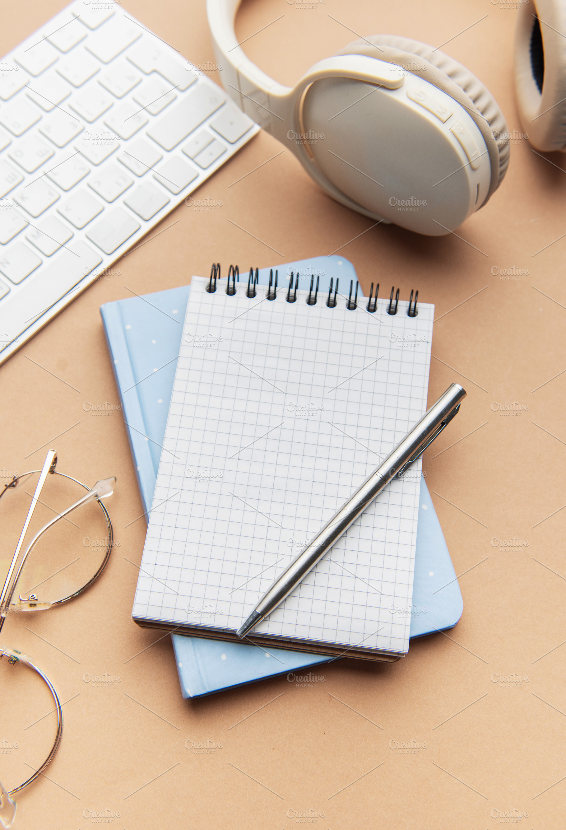 Workspace with notebook, pen, headphones, and keyboard, a School & Education Photo by Olena Rudo