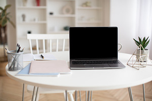 Laptop Computer With Empty Screen Standing On Table At Home, a Photo by Prostock-Studio