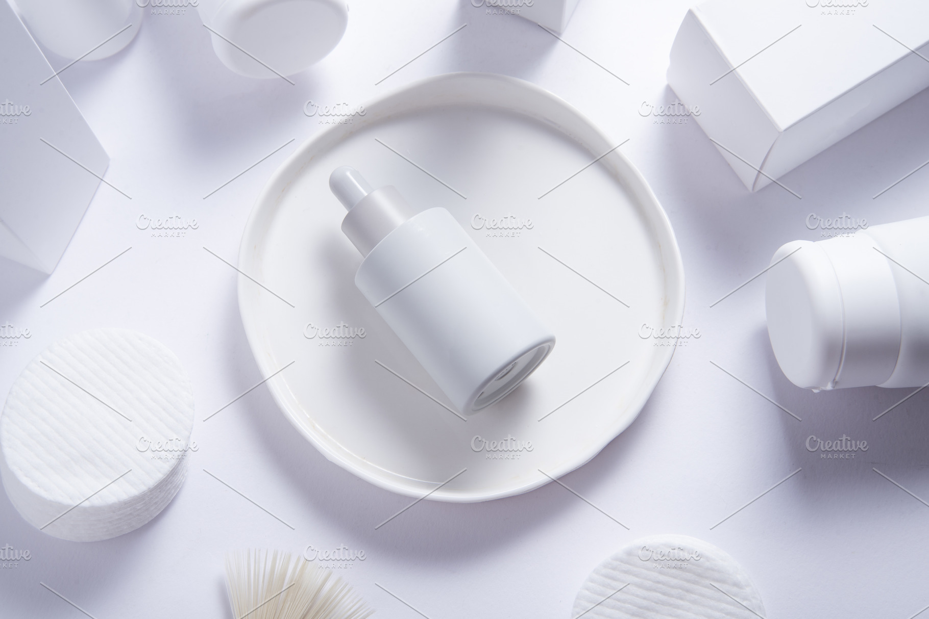 Top view of cosmetic serum bottle on white tray with skincare pr, an Industrial Photo by MDBildes
