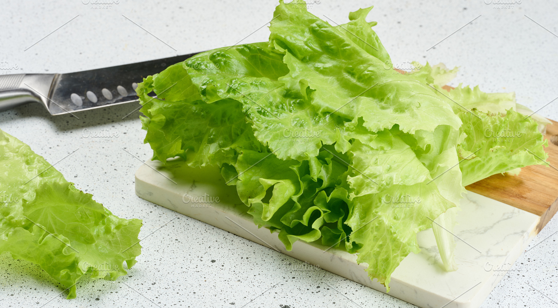 Fresh, crisp lettuce leaves are arranged on a white and wooden c, a Food & Drink Photo by ndanko