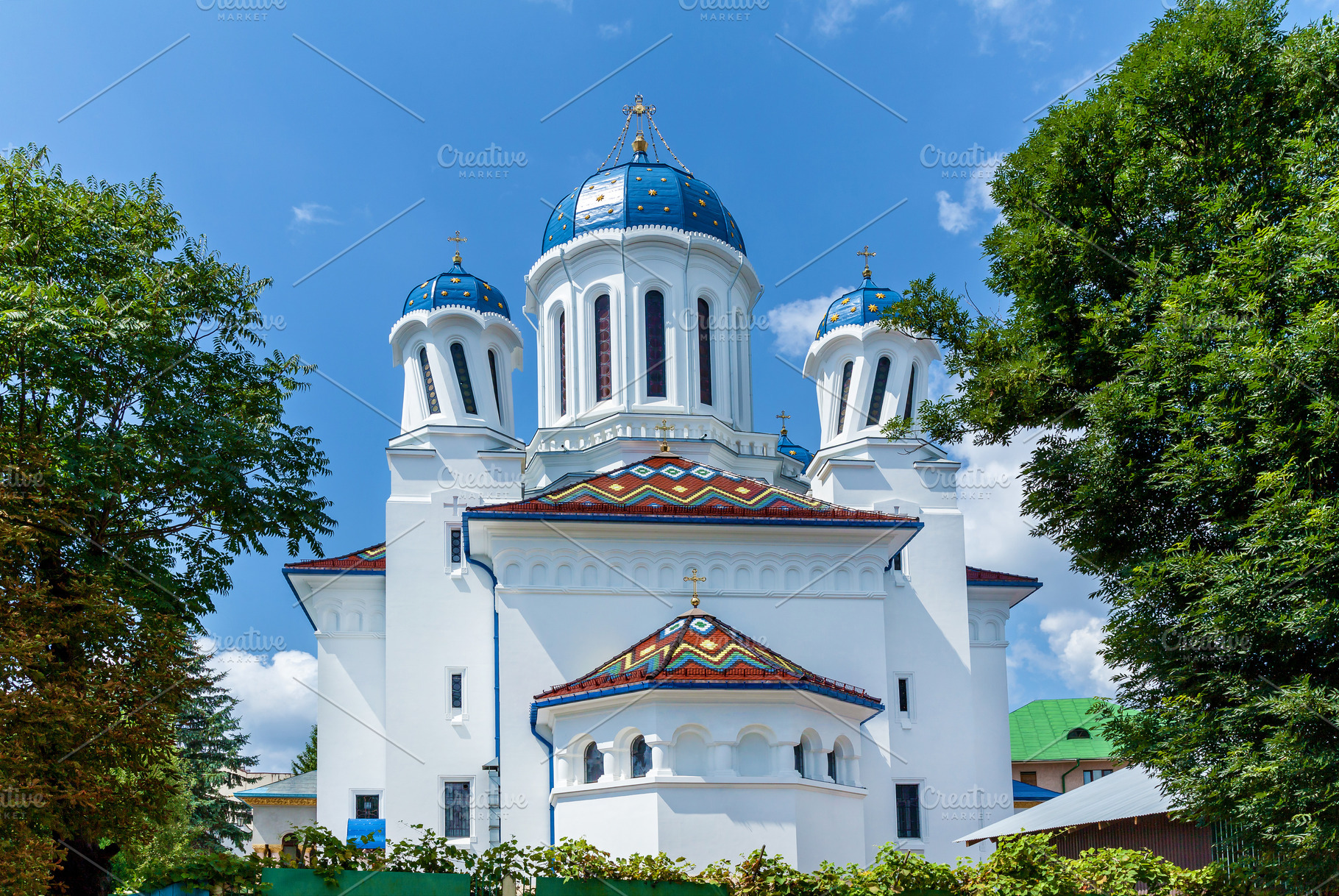 Orthodox church with blue domes and colorful roof tiles, an Architecture Photo by Photostock