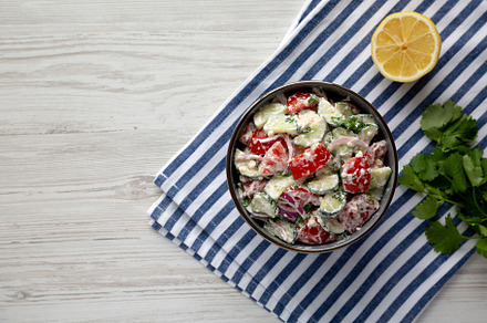 Homemade Tomato Cucumber Feta Salad in a Bowl, top view. Flat la, a Food & Drink Photo by LiudmylaChuhunova