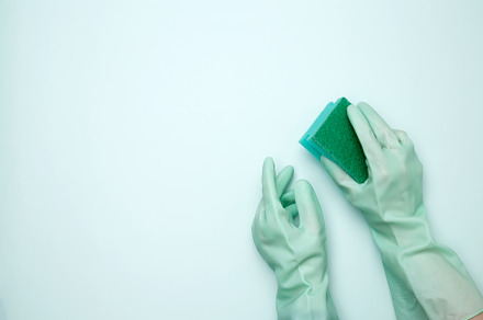 Womans hand in rubber glove holds dishwashing sponge. House cleaning. Copy spac, a Photo by matucha