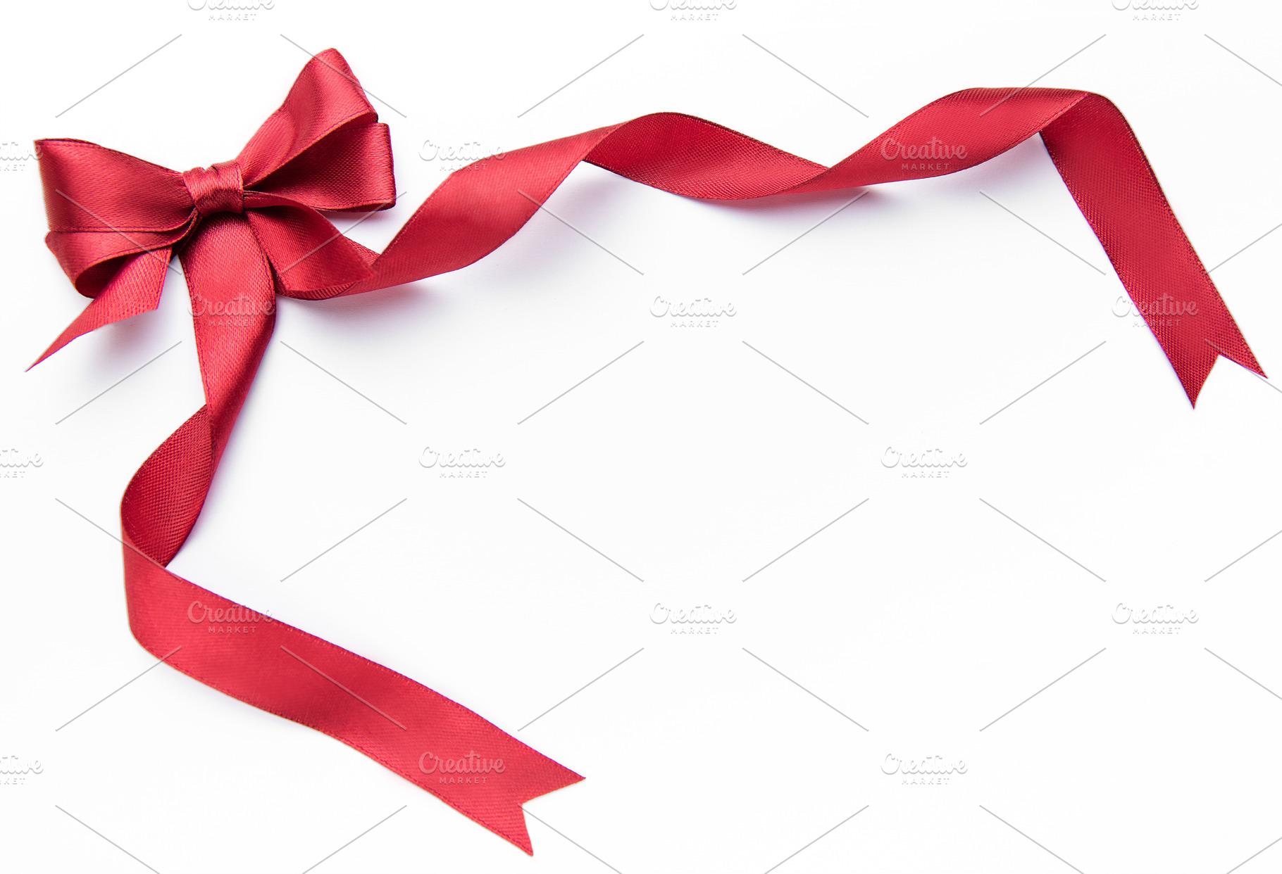 Red satin ribbon bow framing white background, a Holiday Photo by Olena Rudo