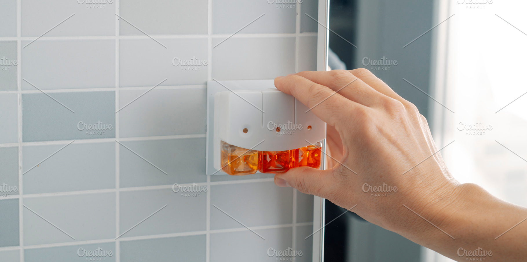man plugging a plug-in air freshener, a Photo by Nito
