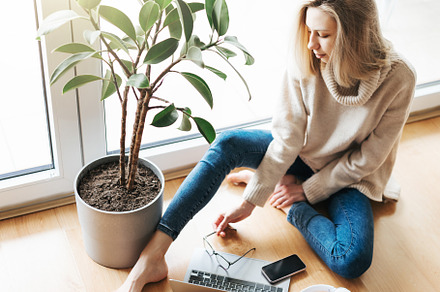 Young woman using her laptop while sitting on the floor at home., a Person Photo by Olena Rudo