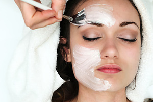 Beautician applying a facial mask with a brush in a spa, an Abstract Photo by Antonio Gravante Market