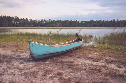 Small Motorized Canoe on Lake Shore
