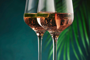 Rose pink wine with jalapeno pepper in wine glass, dark backgrou